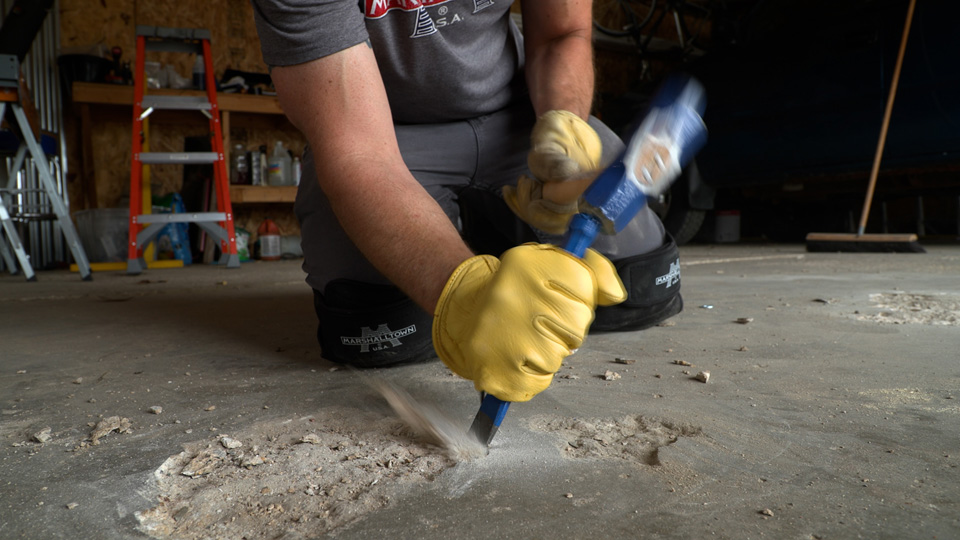 removing damaged concrete with a hammer and chisel